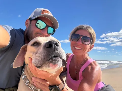 Helen on the beach with family and their dog
