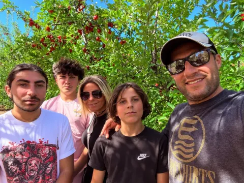 Helen and her family under a cherry tree in an orchard