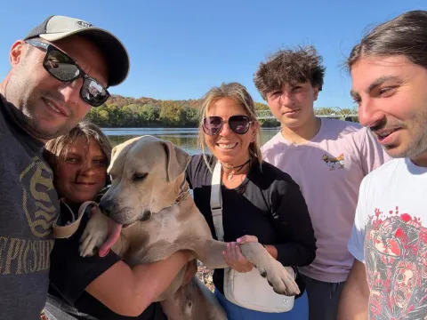 Helen and her family with their dog by a river