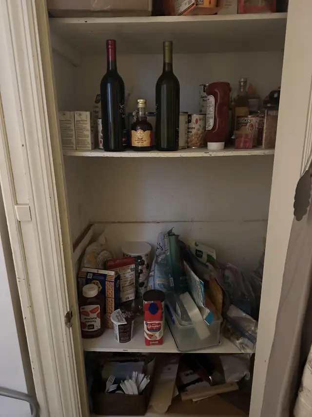 A pantry before organizing, with items crowded on the shelves